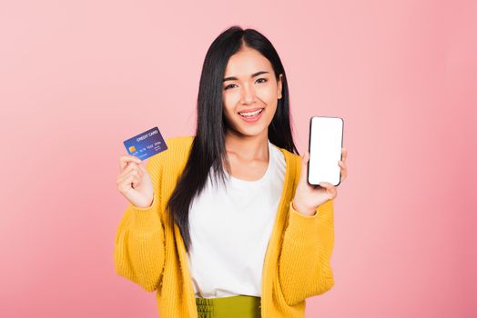 Happy Asian portrait beautiful cute young woman excited smiling hold mobile phone and plastic debit credit bank card