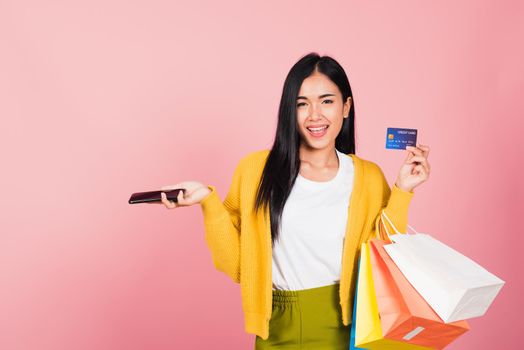 woman shopper smiling standing excited holding online shopping bags colorful and credit card