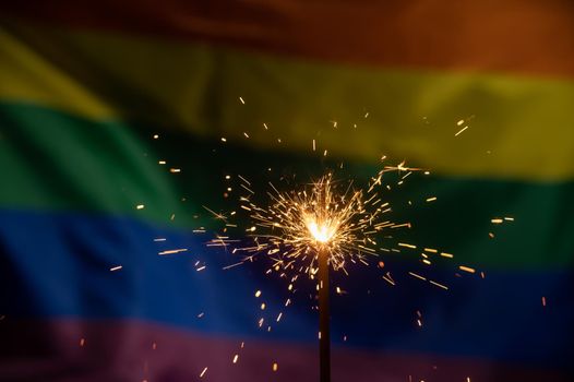 Sparklers with waving lgbt rainbow flag background.