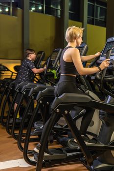Elliptical trainer young woman person, In the afternoon female exercise in home girl coach, active trainer. Cardio lifestyle background, equipment