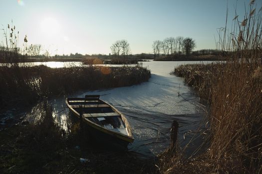 A boat at the edge of a frozen lake