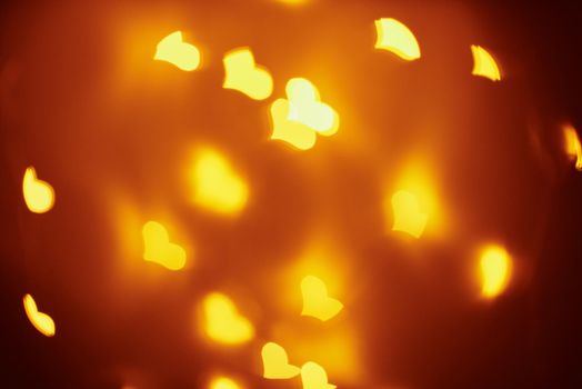 Abstract background with golden blurred lights in heart shape. Valentine day concept