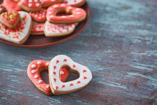 Two heart shape cookies and many decorated cookies on the gray background. Valentines Day concept