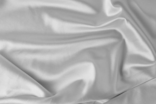 Gray silk background with folds. Abstract texture of rippled satin surface