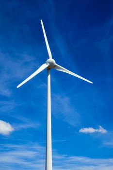 Green renewable alternative energy concept - wind generator turbines generating electricity in blue sky