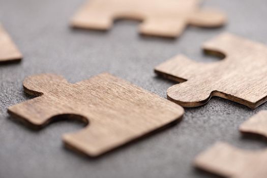 Creative idea and solve the problem concept. Teamwork success strategy - wooden puzzle on the grey background