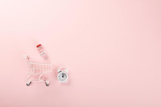 Shopping cart with vaccine vials bottles and syringes for vaccination against coronavirus