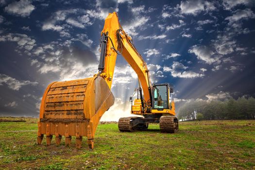 A stopping yellow excavator at an incredibly beautiful sky
