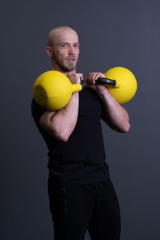 Guy with a yellow kettlebell gym anonymous yellow male, in the afternoon sporty teenager from men from floor weightlifting, asian filipino. Living interval cardio, circuit hiit