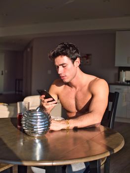 Young man using cell phone during breakfast
