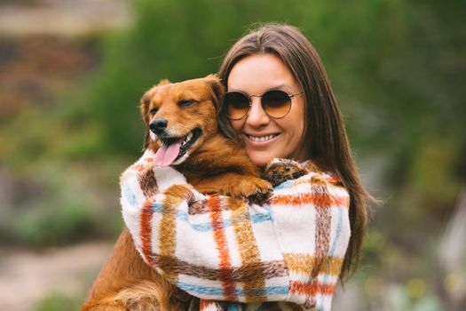 Woman hugging and holding dachshund dog in arms. Dog and owner together, best friends