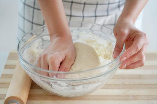 Woman kneading dough in a bowl, close-up