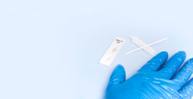 Covid-19 positive test result with SARS CoV-2 Rapid antigen test kit (ATK) on blue floor with copy space,Coronavirus infectious protective concept