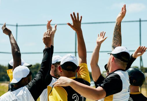 Raise your hand if youre about to give in your best. Cropped shot of a team of young baseball players cheering with their arms raised while standing on the field during the day.