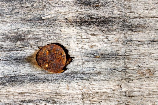 Close up shot of wood board with a rusty nail