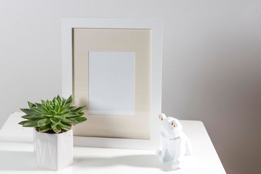 Echeveria in a geometric pot next to a photo frame and a wooden bear figurine. Layout. Place for text. Scandinavian style