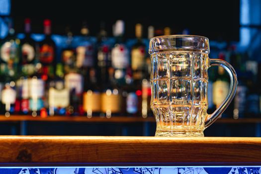 Empty beer glass on a wooden bar counter