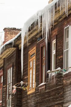 Sharp transparent icicles hang on the edge of the roof.