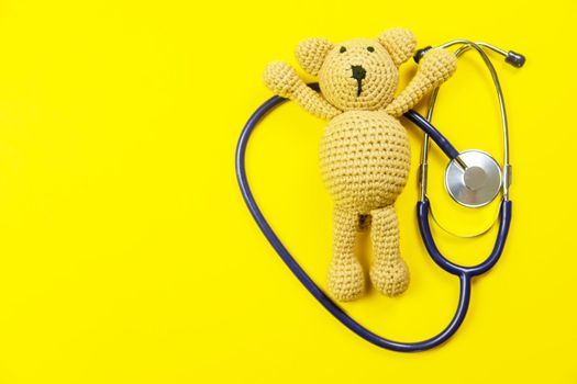 toy, teddy bear on a yellow background stanendoscope. selective focus