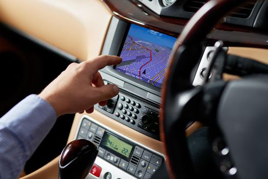Closeup shot of a driver using a cars GPS to find directions.