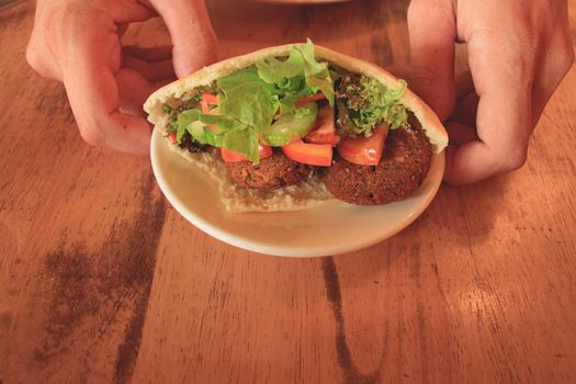 A serving of pita bread stuffed with falafel and fresh vegetable salad