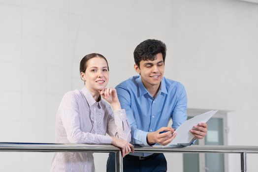 young woman and colleague discuss document