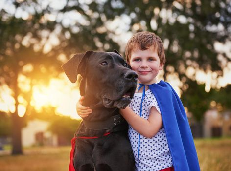 Real heroes never stand alone. Shot of a little boy and his dog wearing capes while playing outside.