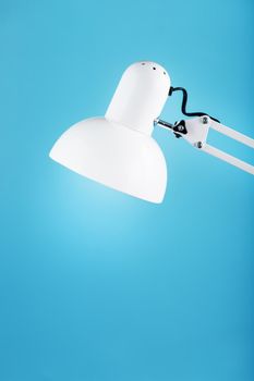 White table office lamp on blue background with space for text and idea concept