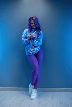 a girl in stylish purple sportswear and with purple hair poses sexually