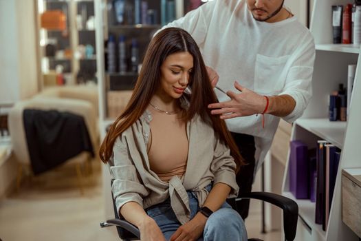 A woman gets a haircut in a beauty salon. Hair care styling concept
