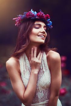 Things that make us happy tell us who we are. Shot of a beautiful young woman wearing a floral head wreath outdoors.