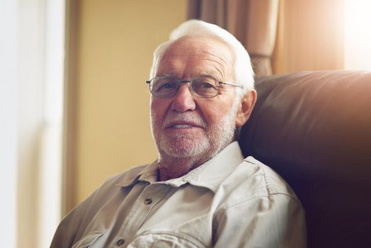 Im comfortable with getting older. Cropped portrait of a happy senior man relaxing on the sofa at home.