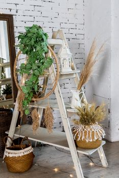scandinavian decoration for cozy home made with dry herbs, lantern, candles and garlands on brick background.Dried flowers and vegetation in a modern interior. Interior decor in eco-style