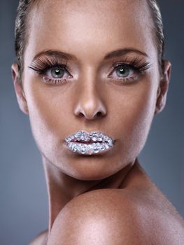 Million dollar kisses. Studio shot of a beautiful young woman with sparkling lips.