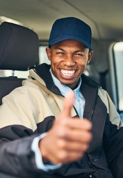 Were committed to deliver no matter what. Portrait of a courier showing thumbs up while driving a delivery van.