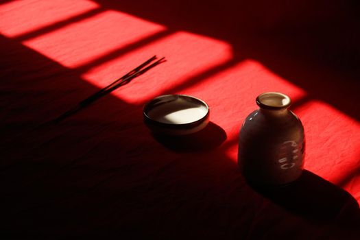 Light and shadows cast on a ceramic incense holder and sticks