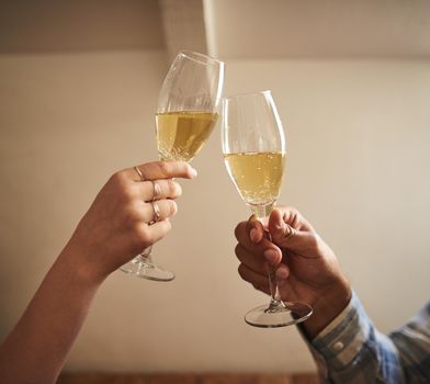 Cheers to us. Shot of an unrecognizable couple toasting at a cafe.