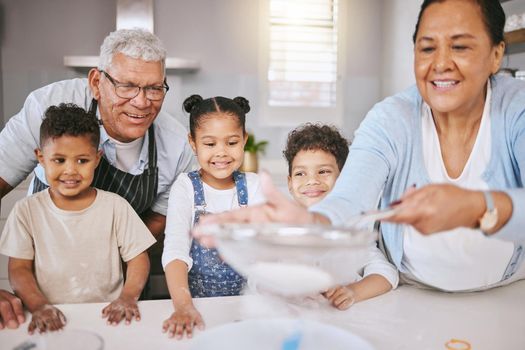 Learning family secrets. Shot of a mature couple baking with their grandkids at home.