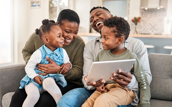 Family friendly movies make the best childhood memories. Shot of a happy young family using a digital tablet on the sofa at home.