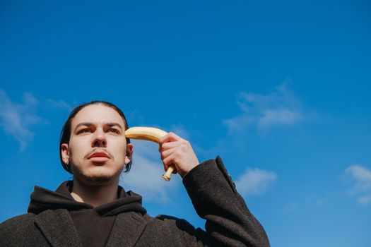 young gay hipster make banana suicide at the street