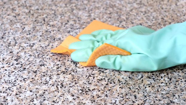 Hand Cleaning Kitchen Work Surface with Rubber Gloves and Disinfectant Spray. The concept of cleaning, help around the house