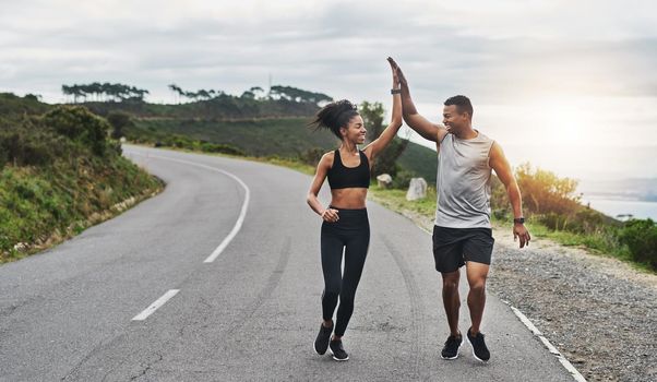 What an amazing run that was. Shot of a sporty young couple high fiving each other while exercising outdoors.