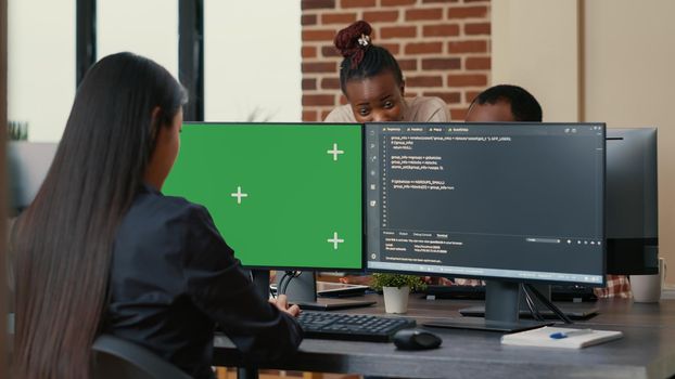 Software developer writing algorithm in front of computer with green screen chroma key mockup