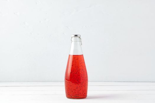 Basil seed drink in glass bottle on white background, close up