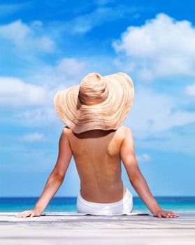 Soaking in the beauty. A sun kissed woman relaxing on the beach in a bikini.
