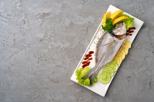 Fresh sea fish with lemon on plate
