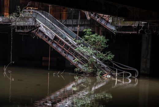 Bangkok, Thailand - 07 Feb 2022 : Damaged escalators and waterlogged in abandoned shopping mall building. Structural and ruins was left to deteriorate over time, New World Mall, Selective focus.