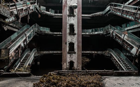 Damaged escalators in abandoned shopping mall building. 