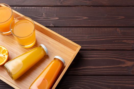 Fresh orange juice in the glass with orange fruit on wooden background