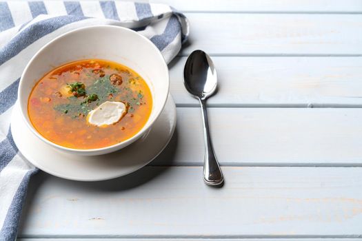 Homemade vegetable soup served with sour cream on wooden background